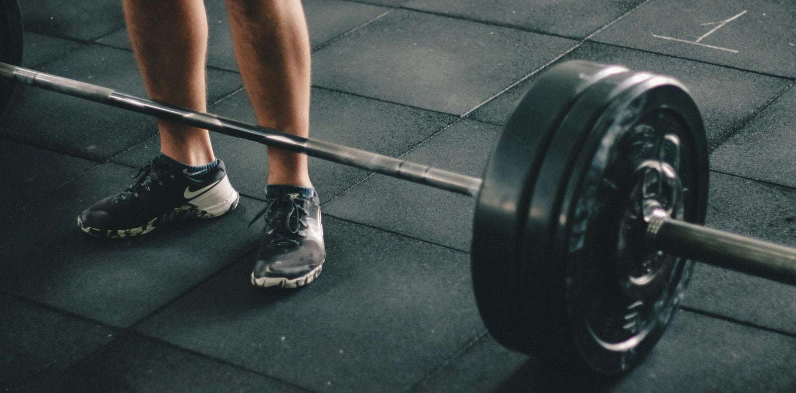 Person förbereder marklyft med skivstång på gym – styrketräning för muskler och prestation